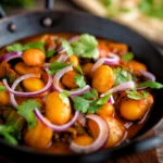Indian vegan butter bean curry served with coriander and red onion.