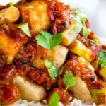 Close up crispy fried tofu with a spicy Vietnamese tomato sauce.
