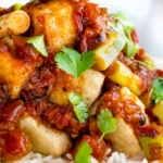 Close up crispy fried tofu with a spicy Vietnamese tomato sauce.