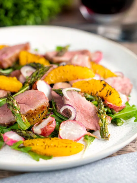 Duck breast salad with rocket, roasted radish and asparagus with orange segments.