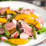 Duck breast salad with rocket, roasted radish and asparagus with orange segments featuring a title overlay.