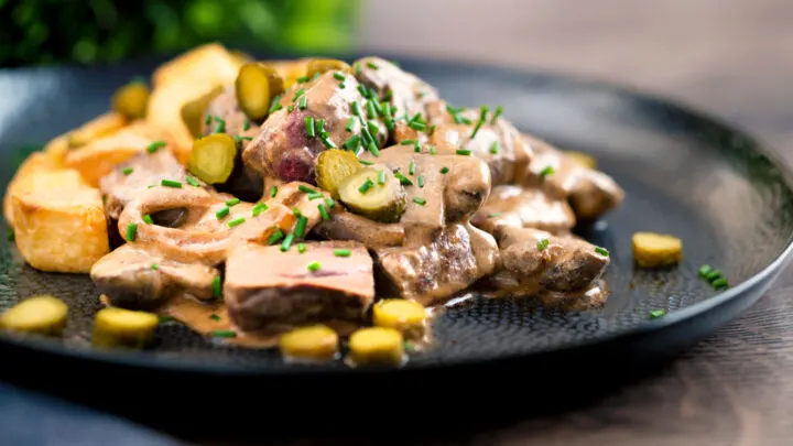 Beef and mushroom stroganoff served with fried potatoes and cornichons.