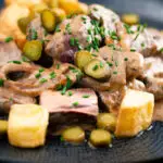 Beef and mushroom stroganoff served with fried potatoes and pickles.