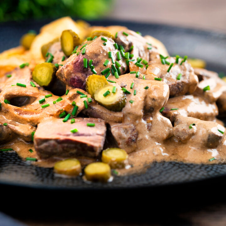 Beef and mushroom stroganoff served with fried potatoes and cornichons.
