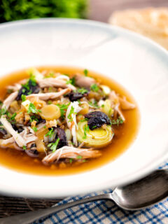 Scottish cock a leekie soup, chicken and leek soup in a white bowl.