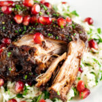 Iranian fesenjan chicken thigh stew with pomegranate showing cooked meat texture.