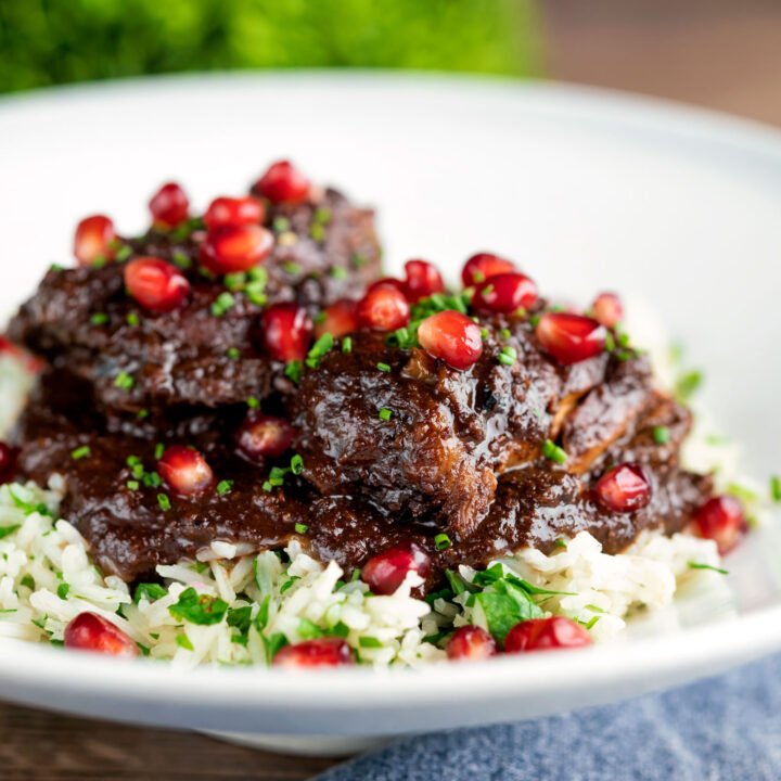 Iranian fesenjan chicken thigh stew with pomegranate & walnut served on herbed rice.