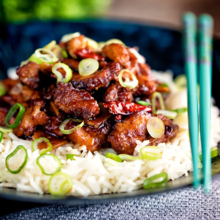 General Tso's chicken fakeaway recipe served on white rice in a blue bowl.