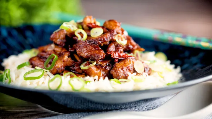 General Tso's chicken fakeaway recipe served on white rice in a blue bowl.