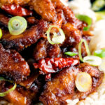 Close up General Tso's chicken fakeaway recipe served on white rice featuring a title overlay.