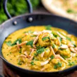 Chicken korma curry garnished with coriander and almonds.