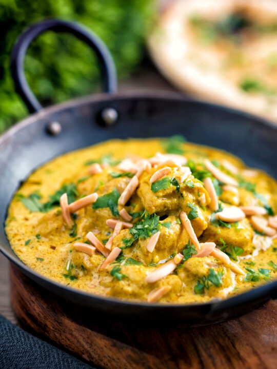 Chicken korma curry garnished with coriander and almonds.