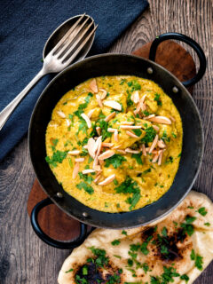 Overhead chicken korma curry garnished with coriander and almonds.