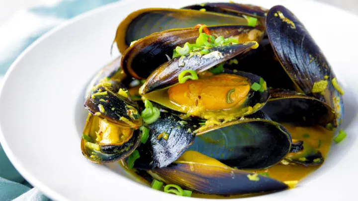 Indian curry mussels served in the shells in a coconut milk sauce.