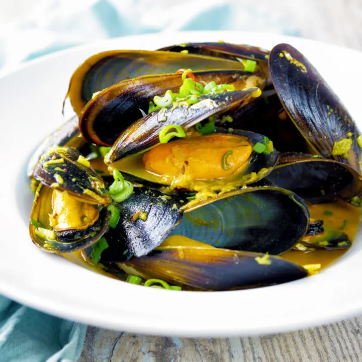 Indian curry mussels served in the shells in a coconut milk sauce.