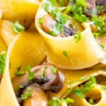 Close up garlic mushroom pappardelle with parsley.