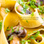 Close up garlic mushroom pappardelle with parsley featuring a title overlay.