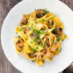 Garlic mushroom pappardelle with balsamic vinegar served in a white bowl.