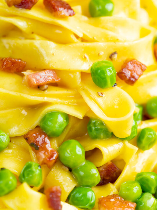 Close up tagliatelle carbonara with peas and bacon.