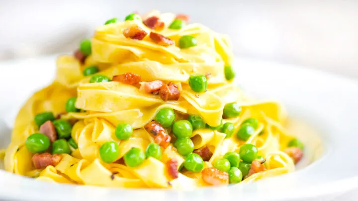 Silky pasta carbonara with peas, bacon and tagliatelle pasta.