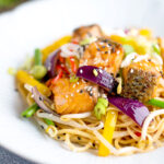Salmon stir fry with egg noodles and vegetables.