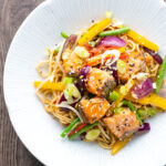 Overhead salmon stir fry with egg noodles and vegetables.