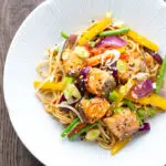 Overhead salmon stir fry with egg noodles and vegetables.
