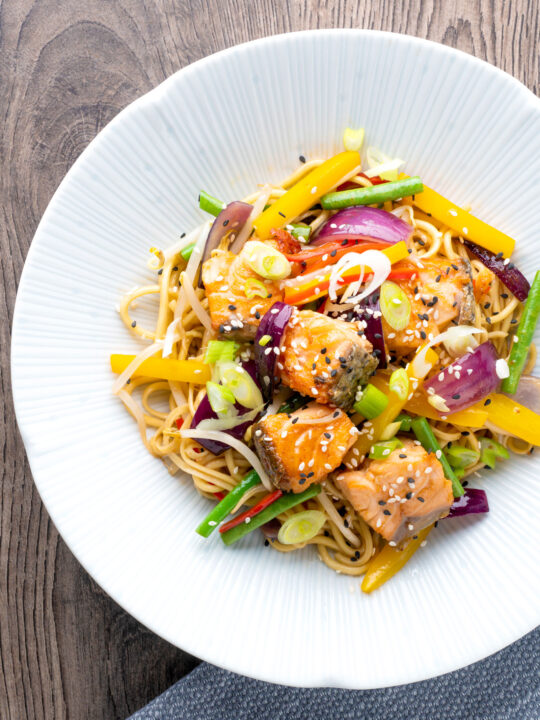 Overhead salmon stir fry with egg noodles and vegetables.