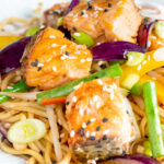 Close up salmon stir fry with egg noodles and vegetables.