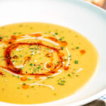 Turkish lentil soup or mercimek corbasi with paprika butter and tahini swirls.