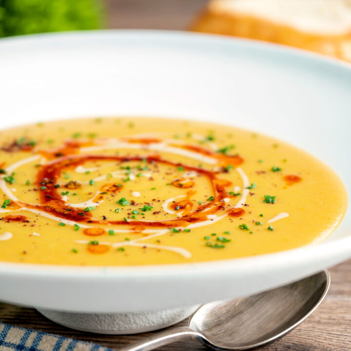 Turkish lentil soup or mercimek corbasi with paprika butter and tahini swirls, sumac & chives.