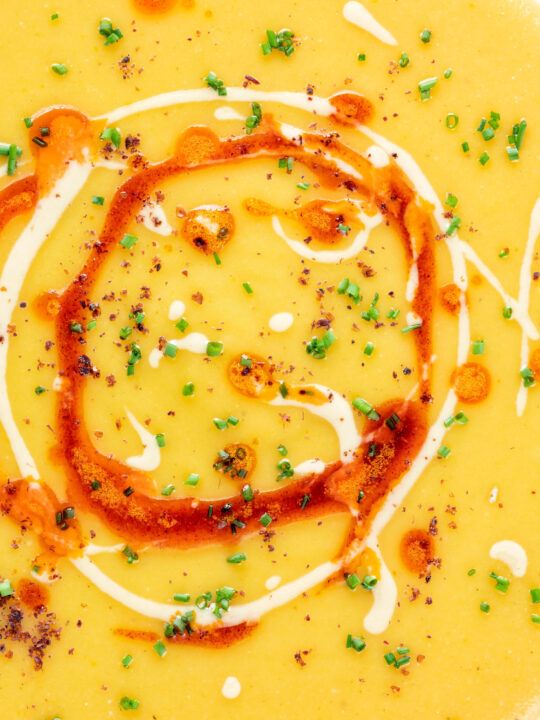 Close up Turkish lentil soup or mercimek corbasi with paprika butter and tahini swirls.