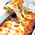 Goats cheese cannelloni with spinach being served showing stringy cheese.