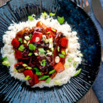 Overhead honey chilli chicken made with chicken tenders, red peppers and spring onions.
