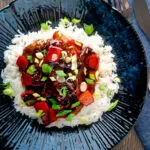 Overhead honey chilli chicken made with chicken tenders, red peppers and spring onions.