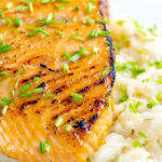 Honey mustard salmon fillet served on celeriac mash with snipped chives featuring a title overlay.