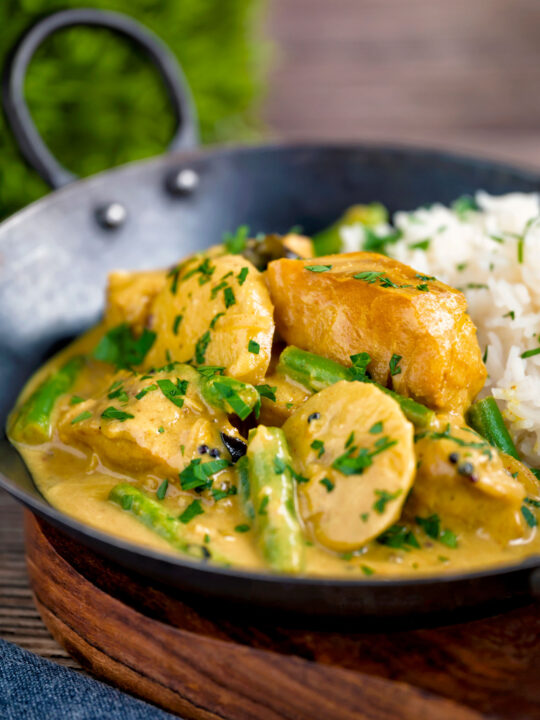 Keralan fish curry with coconut milk featuring green beans and potato in a karai.