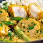 Keralan fish curry with coconut milk showing the texture of the cooked white fish.