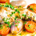 Close up of the vegetables in a rabbit cacciatore served on polenta.