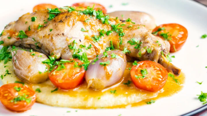 Rabbit Cacciatore or Coniglio alla Cacciatora with shallot, cherry tomatoes and polenta porridge.