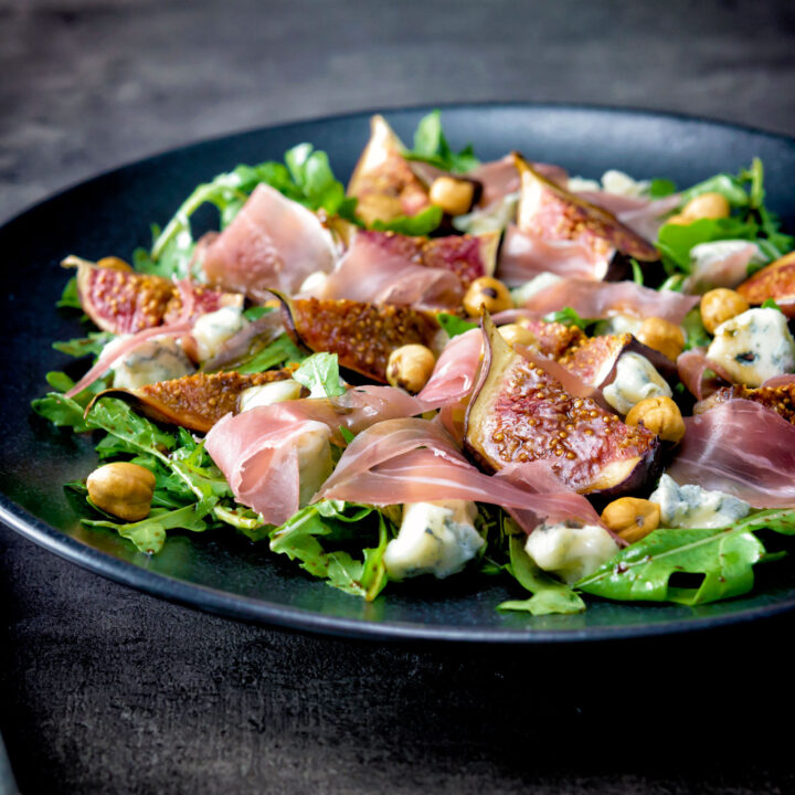 Roasted figs in a salad with prosciutto ham, rocket, blue cheese and hazelnuts.