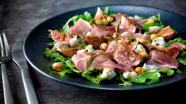 Roasted figs in a salad with prosciutto ham, rocket, blue cheese and hazelnuts.