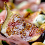 Close up roasted figs served in a salad featuring a title overlay.