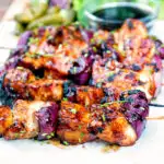 BBQ chicken skewers with pineapple and red onion with a sweet and sour glaze featuring a title overlay.