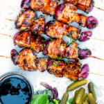 Overhead BBQ chicken skewers with pineapple & red onion with a sweet and sour glaze featuring a title overlay.