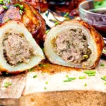 Stuffed onions wrapped in bacon & BBQ sauce cut open showing beef stuffing.