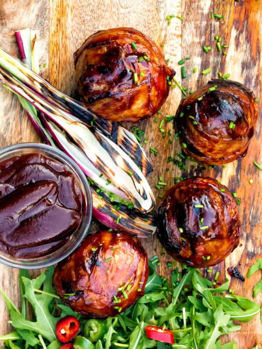 Overhead stuffed mushrooms wrapped in bacon & BBQ sauce glaze.