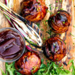 Overhead stuffed onions wrapped in bacon & BBQ sauce glaze featuring a title overlay.