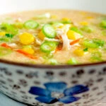 Chinese style chicken and sweetcorn soup served in a flower decorated bowl.