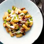 Overhead pan fried gnocchi with bacon, broad beans and parmesan shavings.